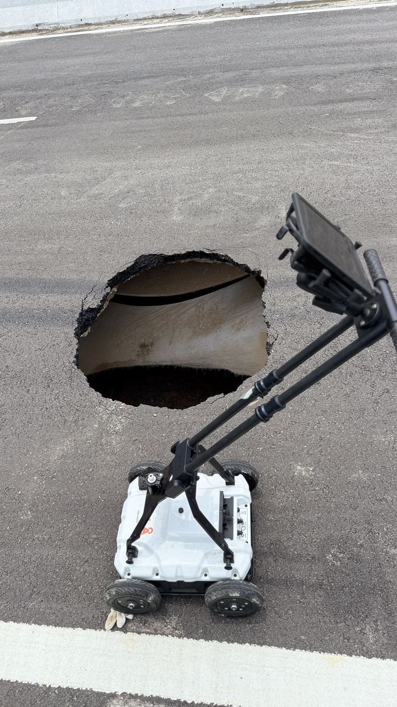 GPR survey cart being used to scan near a sinkhole in a road surface